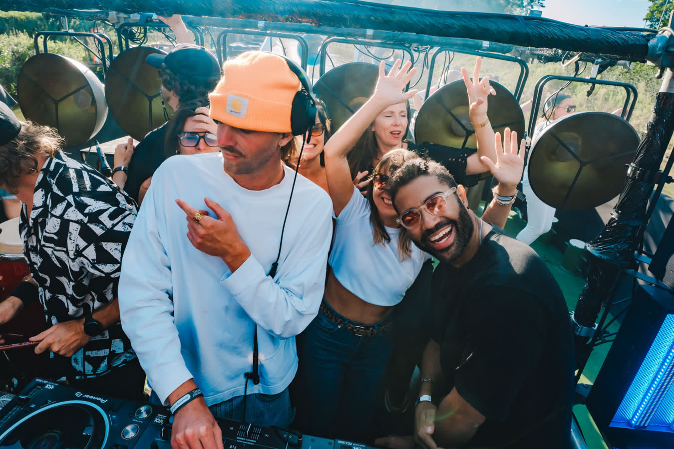 DJ en publiek achter de decks in de zon