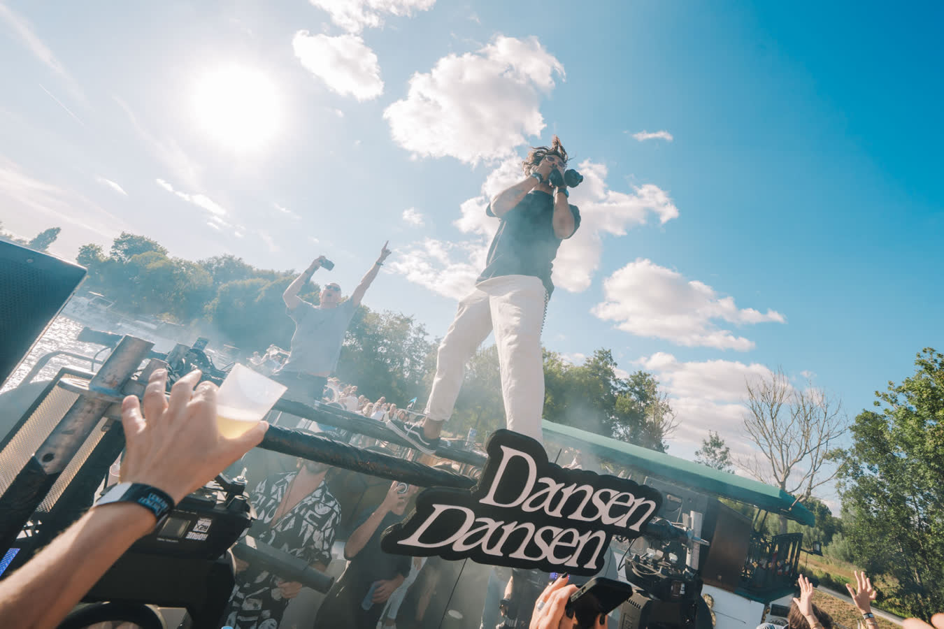 Artiest op het podium in de zon met Dansen Dansen bord