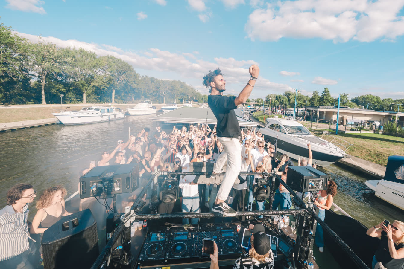 Feestend publiek aan het water tijdens een boat party
